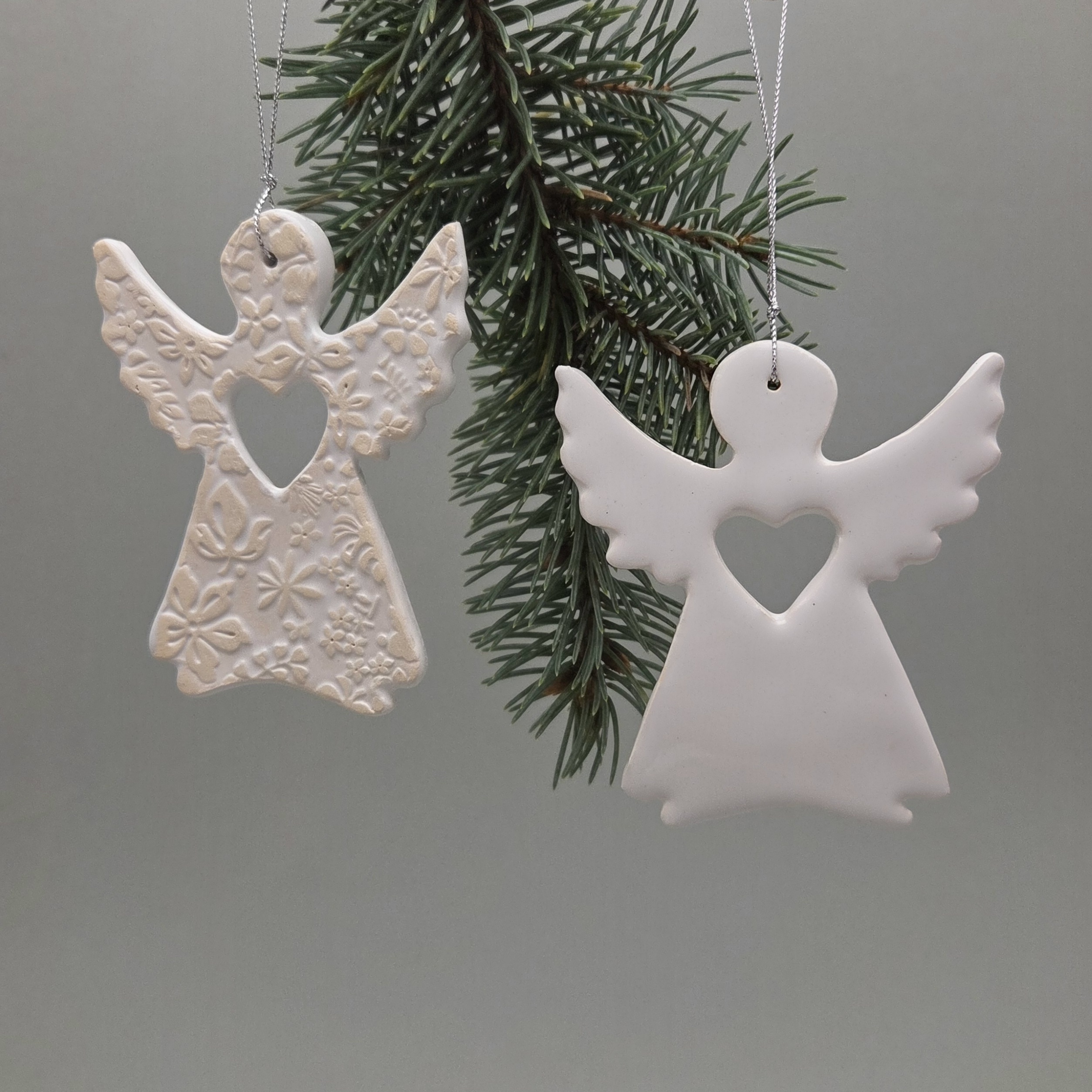 Baltas rankų darbo keraminis angeliukas su širdelės išpjova ir iškiliu ažūriniu raštu, Kalėdų eglutės papuošimas, apie 9 × 8 cm